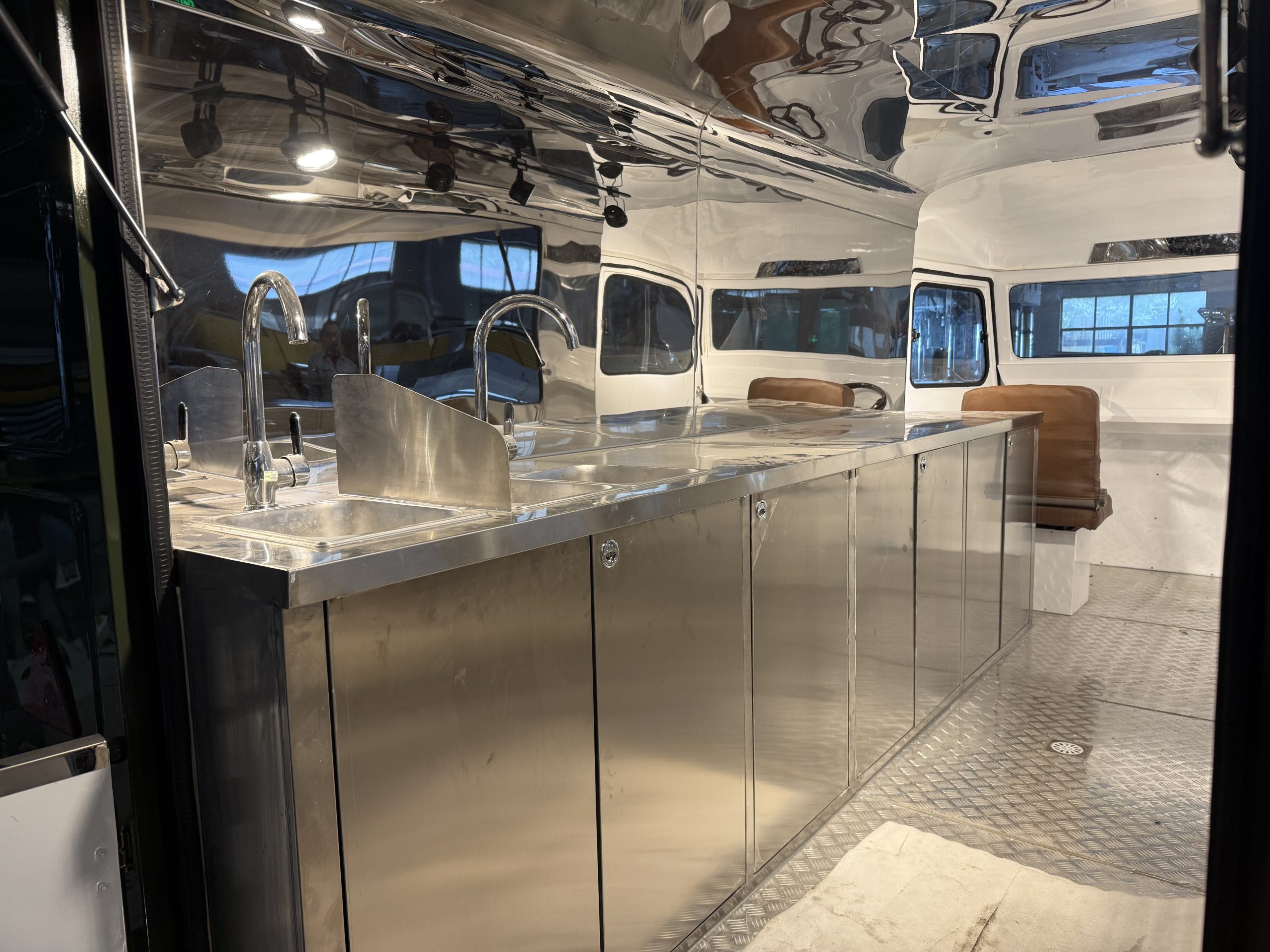Full stainless steel counter and multiple sinks inside food trailer