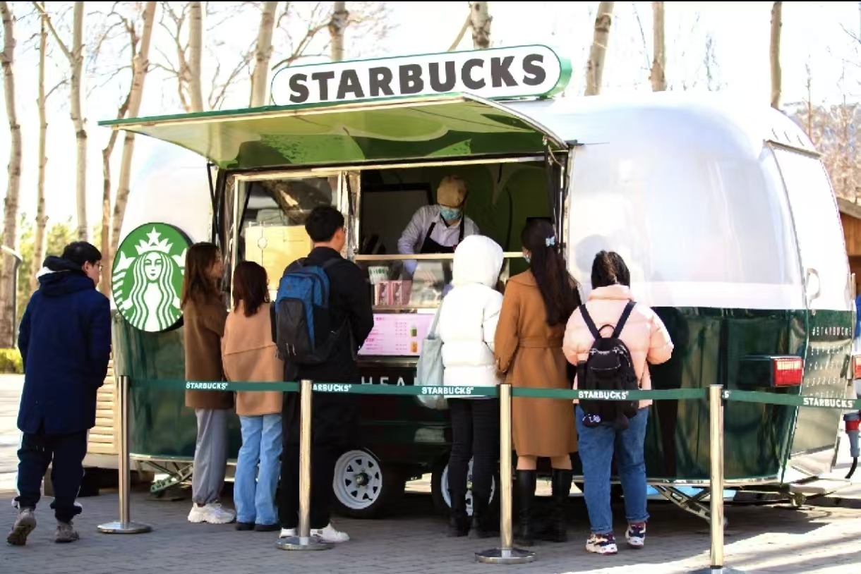 Starbucks style mobile coffee trailer serving customers outdoors